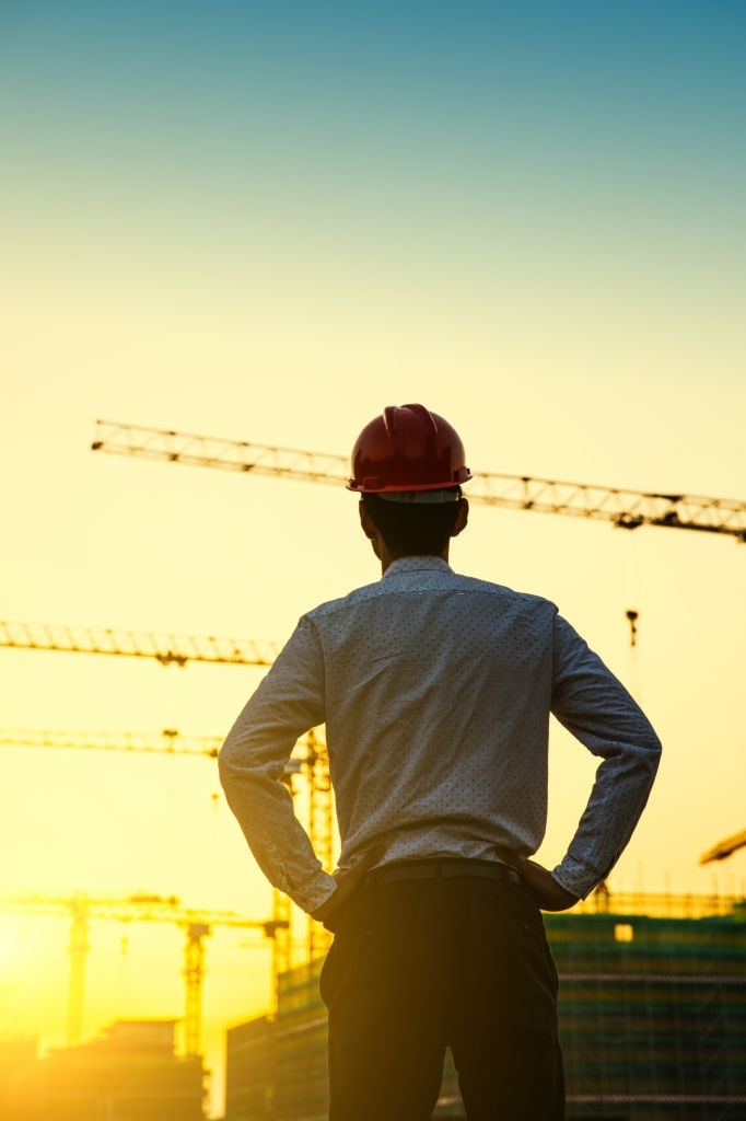 Engineer with crane background at sunset